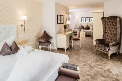 a hotel room with a bed and a living room at Hotel Rössl in Rablà