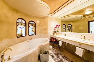a bathroom with a tub and two sinks at Hotel Rössl in Rablà