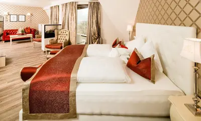 a bedroom with a large bed and a living room at Hotel Rössl in Rablà