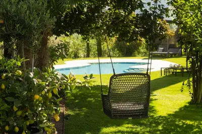 a swing in a yard with a swimming pool at Pension Sandhofer in Nalles