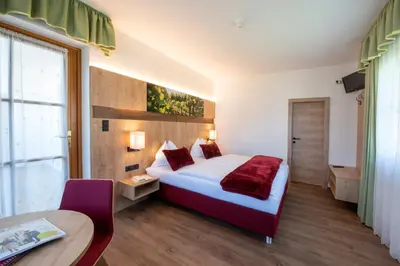 a hotel room with a bed and a table at Pension Sandhofer in Nalles