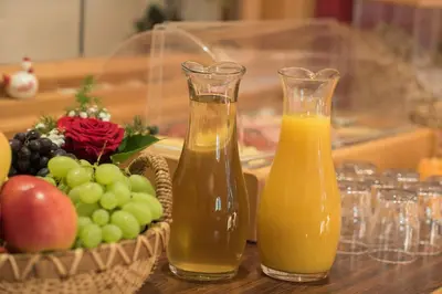 two bottles of orange juice and a basket of fruit at Pension Sandhofer in Nalles