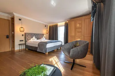 a hotel room with a bed and a chair at Hotel Zum Mohren in Tesimo