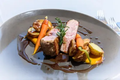 a plate of food with meat and carrots and gravy at Hotel Zum Mohren in Tesimo