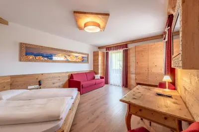 a bedroom with a bed and a large window at Hotel Christine in Gargazzone