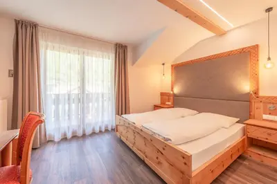 a kitchen with wooden ceilings and a flat screen tv at Hotel Christine in Gargazzone
