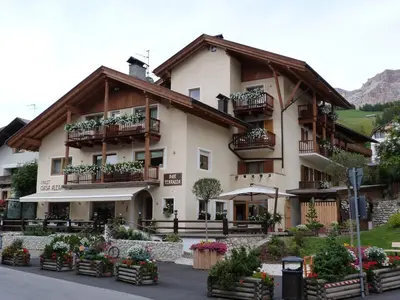 a house in the snow with mountains in the background at Chalet Ciasa Alexander in San Cassiano