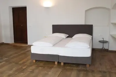 a bed with white sheets and pillows in a room at The Court House in Bressanone