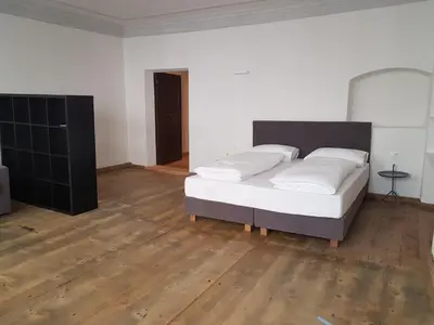 a bedroom with a bed and a wooden floor at The Court House in Bressanone