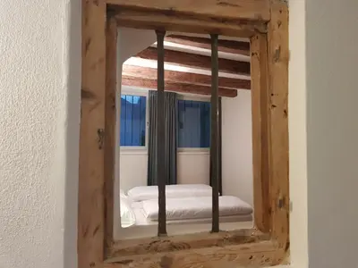 a mirror reflecting a bed in a room at The Court House in Bressanone
