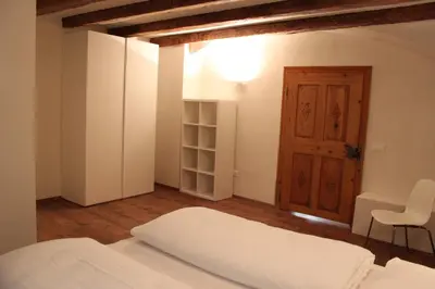 a bedroom with a bed and a wooden door at The Court House in Bressanone
