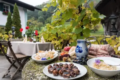 a table with plates of food and a vase at Gasthof Tschötscherhof in Castelrotto
