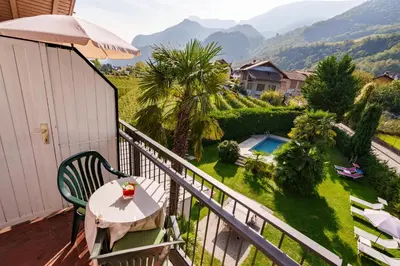 a balcony with a table and an umbrella at Hotel Appartement Lahngut in Nalles