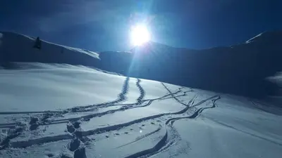 a snow covered slope with the sun in the background at Hotel Appartement Lahngut in Nalles