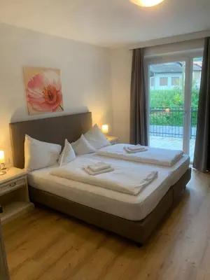 a large bed in a bedroom with a window at Hotel Appartement Lahngut in Nalles