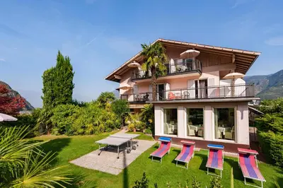 a house with chairs and a table in front of it at Hotel Appartement Lahngut in Nalles