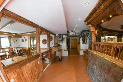 a large room with wooden walls and a dining room at Hotel El Laresh in Moena