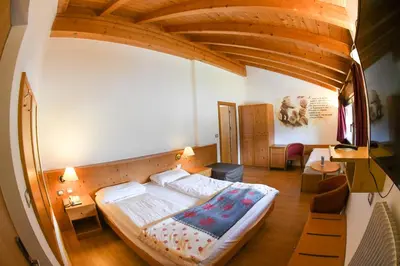 a bedroom with a large bed in a room at Hotel El Laresh in Moena