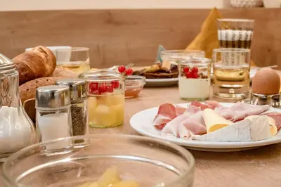 a table topped with plates of meat and other foods at Rebenheim in Termeno