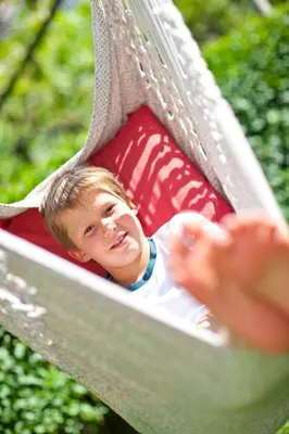 a young boy is sitting on a slide at Rebenheim in Termeno