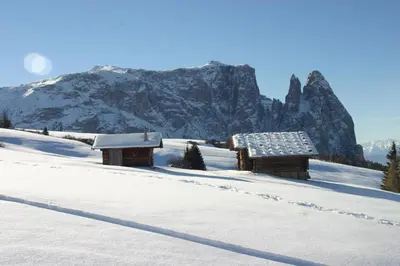 two benches sitting on top of a snow covered hill at Tomasoethof in Castelrotto