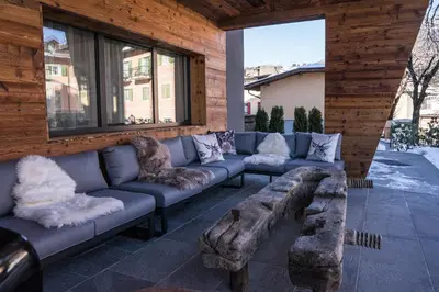 a living room with a couch and a table and chairs at Hotel San Valier in Cavalese