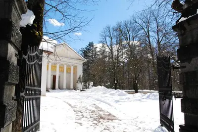 a gate to a white house in the snow at Hotel San Valier in Cavalese