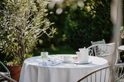 a white table with cups and saucers on it at Waidmannhof in Merano