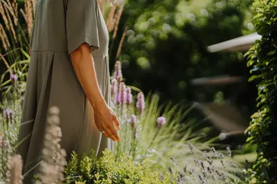 a woman standing in a garden with purple flowers at Waidmannhof in Merano