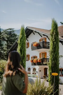 a woman walking in front of a house at Waidmannhof in Merano