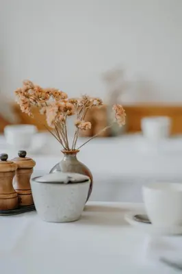 a vase with flowers in it sitting on a table at Waidmannhof in Merano