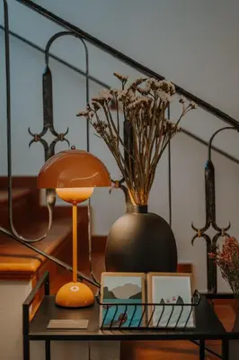 a table with a lamp and a vase on it at Waidmannhof in Merano