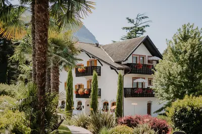 a house with palm trees in front of it at Waidmannhof in Merano
