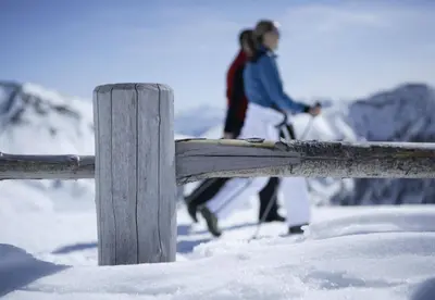 a woman is standing on a fence in the snow at Hotel Mitterplatt (Schenna Resort) in Schenna