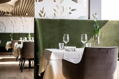 a dining room with a table with wine glasses at Hotel Mitterplatt (Schenna Resort) in Schenna