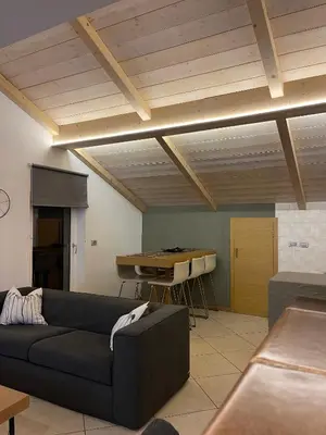 a living room with a couch and a table at Mansarda Ciliegio Cavalese in Cavalese