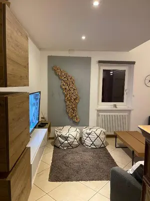 a living room with a flat screen tv and a couch at Mansarda Ciliegio Cavalese in Cavalese