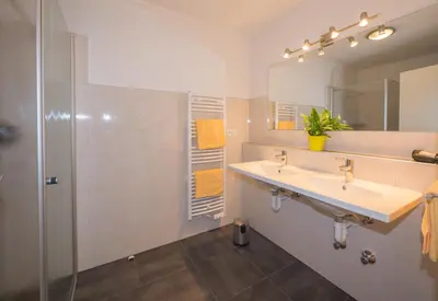 a bathroom with two sinks and a shower at Gasserhof Garni & Apartment in Schenna