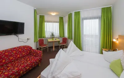 a hotel room with a bed and a couch and a table at Gasserhof Garni & Apartment in Schenna