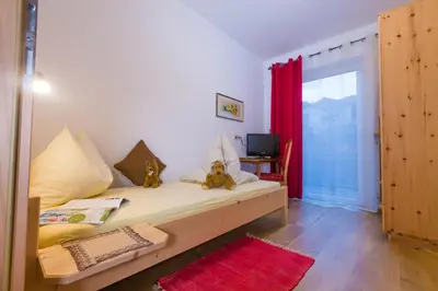 a bedroom with a bed and a red curtain at Gasserhof Garni & Apartment in Schenna