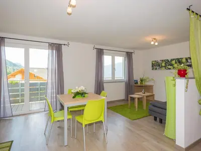a living room with a table and yellow chairs at Gasserhof Garni & Apartment in Schenna