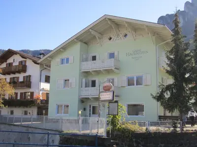 a large building with a sign on the side of it at Garni Hauenstein in Siusi