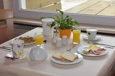 a table with plates of food and glasses of orange juice at Garni Hauenstein in Siusi