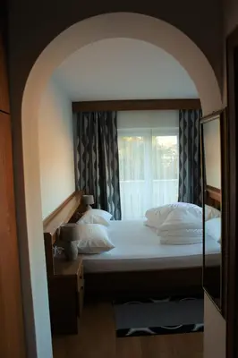 a bedroom with a large bed with a window at Garni Hauenstein in Siusi