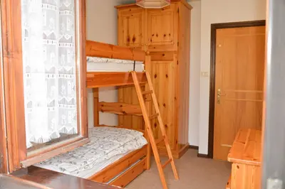 a room with two bunk beds and a ladder at CASA GILDA Val di Fiemme - Dolomiti in Cavalese