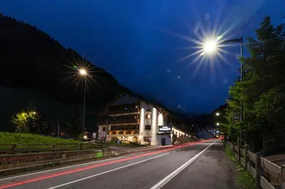 a street at night with street lights on a road at Hotel Casa Alpina - Alpin Haus in Selva di Val Gardena