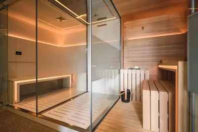 a sauna with glass walls and wooden floors at Apartmenthotel Ritterhof Suites & Breakfast in Schenna