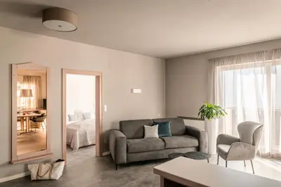 a living room with a couch and a mirror at Apartmenthotel Ritterhof Suites & Breakfast in Schenna