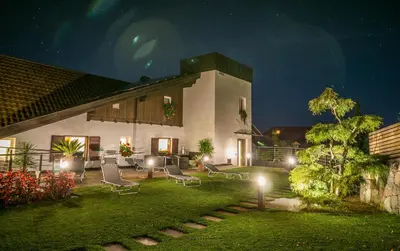 a yard with chairs and a house at night at Drei Birken in Soprabolzano
