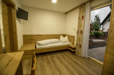 a small room with a bed and a window at Drei Birken in Soprabolzano